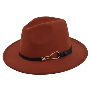 Detail of brick red fedora featuring a black leather band and gold metal buckle