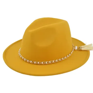 Detail of yellow wool fedora hat with gold pearl chain trim and stylish side tassels