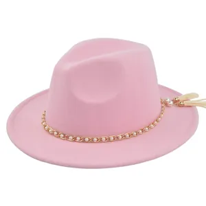 Detail of pink fedora hat featuring a white pearl metal chain and hanging tassels
