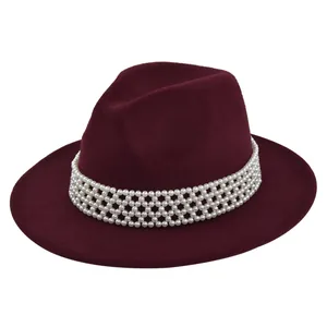 Detail of burgundy wool fedora featuring multi-layer white pearl decorative band