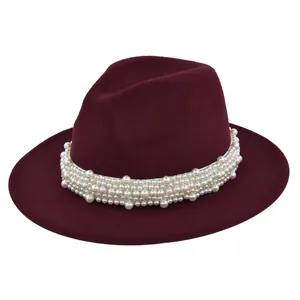 Détail d'un chapeau fedora en laine bordeaux avec un élégant ruban de perles