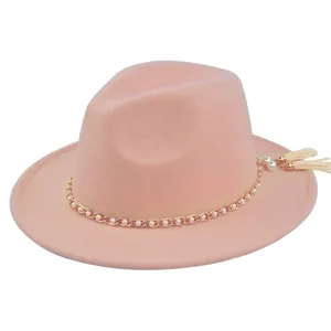 Detail of pink wool fedora featuring gold bead chain and white pearl fringe tassels