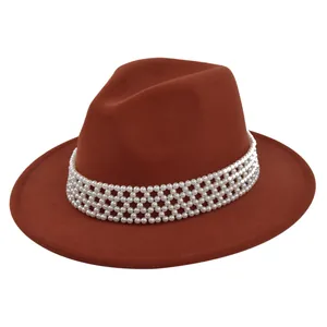 Detailed close-up of pearl beaded band decoration on a caramel wool felt fedora hat