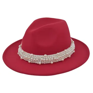 Gros plan sur un chapeau fedora en laine rouge avec bandeau décoratif en perles
