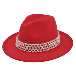 Detailed close-up of a red wool fedora hat with elegant white pearl decorative band
