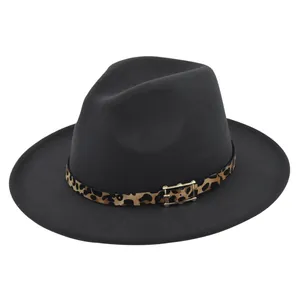 Detalle de sombrero fedora de lana oscura con cinta de leopardo y hebilla dorada chic