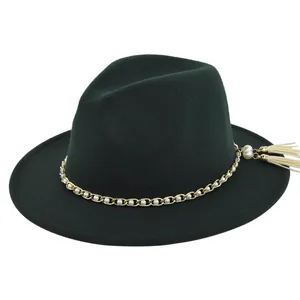 Detail of dark green felt fedora featuring gold chain, white pearls, and cream tassels