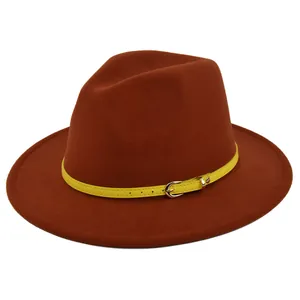 Detail of dark brick red wool fedora hat with a contrasting yellow buckled leather band