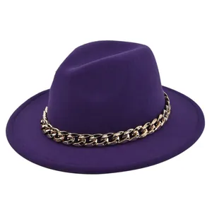Dettaglio del cappello fedora in feltro viola scuro con una grossa catena dorata