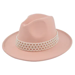 Detail of pink wool fedora hat featuring a luxury four-row white pearl decorative band