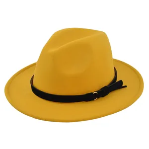 Detailed macro of bright yellow wool fedora hat featuring a black band with gold ring trim