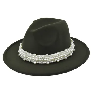 Détail des décorations de perles sur le ruban d'un chapeau fedora en laine vert foncé