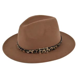 Detalle del cinturón con estampado de leopardo y hebilla dorada en un sombrero fedora marrón.