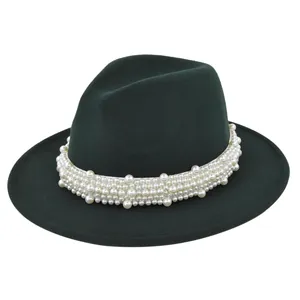 Détail d'un chapeau fedora en laine vert foncé orné d'élégantes perles blanches sur le bord