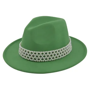 Detail of green wool fedora hat featuring an intricate pearl bead band and soft felt texture