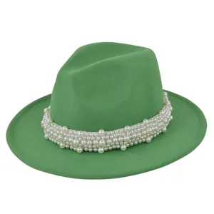 Détail du chapeau fedora en feutre vert orné de rangées de perles blanches élégantes