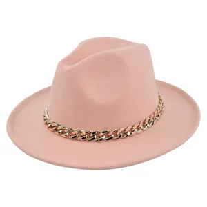 Dettaglio cappello fedora in feltro rosa chiaro con grossa catena in metallo dorato