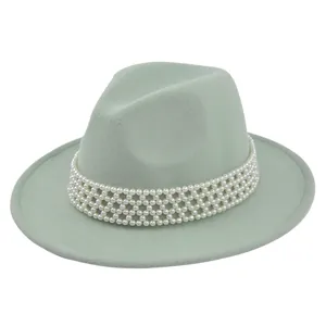 Detail of mint green fedora wool hat featuring a multi-layered white pearl decorative band