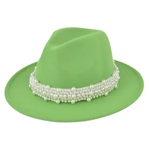 Détail d'un chapeau fedora en feutre vert herbe orné de perles blanches élégantes