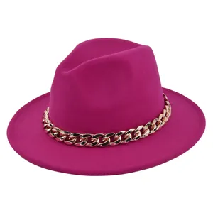 Dettaglio cappello fedora in feltro fucsia con catena dorata su sfondo bianco