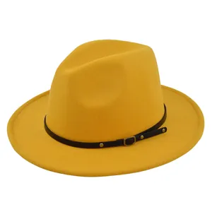 Λεπτομέρεια κίτρινου καπέλου fedora με μαύρη δερμάτινη ζώνη και χρυσά μεταλλικά καρφιά
