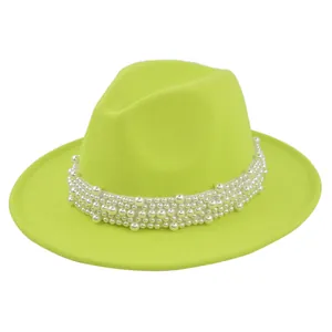 Détail d'un chapeau fedora vert néon avec ruban de perles blanches et texture en feutre
