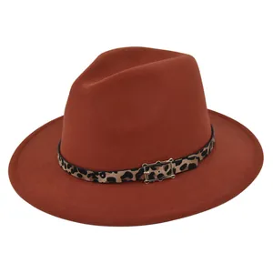 Detalle del sombrero fedora color caramelo con banda de leopardo y hebilla oro