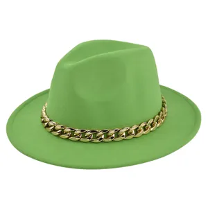 Dettaglio del cappello in feltro verde brillante con una vistosa catena dorata