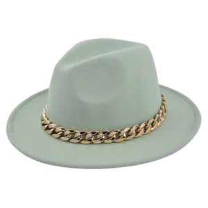 Dettaglio del cappello fedora in lana verde chiaro con catena dorata decorativa