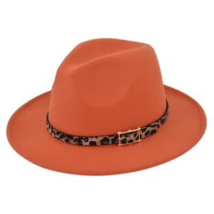 Detalle de sombrero de lana naranja con banda de leopardo y hebilla dorada elegante