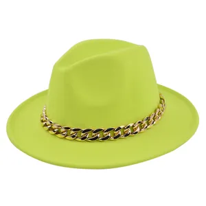 Dettaglio del cappello fedora in lana verde neon con una grossa catena in metallo dorato