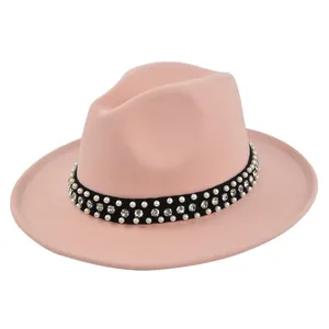 Detail of pink wool fedora with a black band featuring pearls and rhinestones