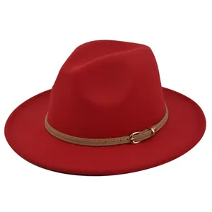 Detail van een rode wollen fedora hoed met een kaki leren riem en gouden metalen gesp