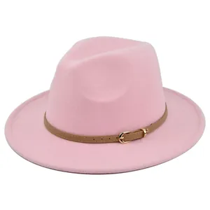 Detailopname van de roze fedora hoed met bruine lederen riem en gouden metalen gesp