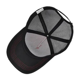 Detailed macro view of black trucker hat interior with 100% cotton label and mesh back