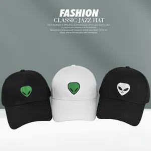 Detailed embroidery of a green alien head on classic black and white baseball caps