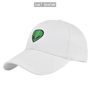 Close-up of green alien embroidery on white baseball cap with detailed black outline