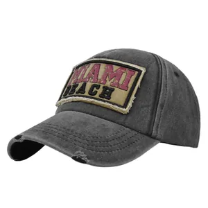 Detailopname van grijze vintage honkbalpet met Miami-patch en versleten details op de rand