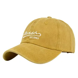 Detail of white Stubble EST.1993 embroidery on mustard yellow vintage baseball cap