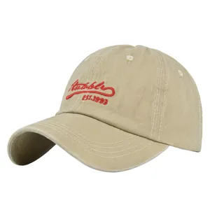 Detail shot of khaki vintage dad hat with red script embroidery and curved brim