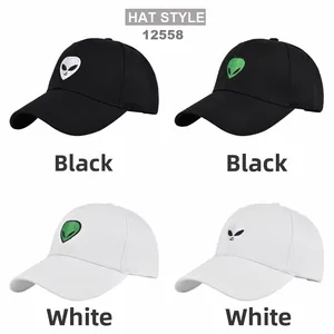 Close-up of black and white baseball caps with green and silver alien head embroidery