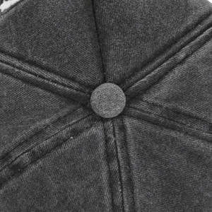 Dettaglio ravvicinato delle cuciture e del bottone del cappellino da baseball in cotone grigio