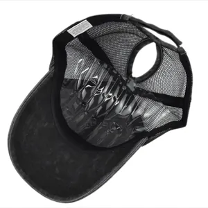 Detail view of ponytail hole and breathable mesh lining of washed gray baseball cap