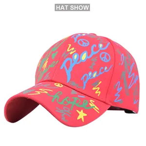 Dettaglio cappellino rosso con motivi graffiti colorati e stampe Peace e Hope