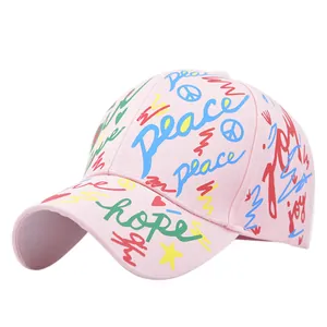Dettaglio del cappellino rosa con motivi graffiti colorati e scritte a mano tipo peace