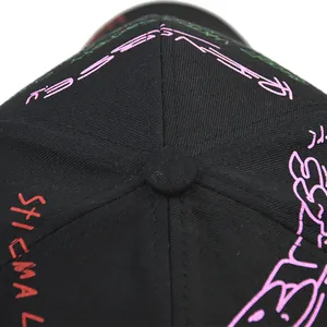 Detailopname van een zwarte baseballpet met roze en groene graffiti-borduurprint