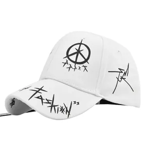 Détail d'une casquette blanche montrant le texte graffiti noir et le logo brodé sur la couronne