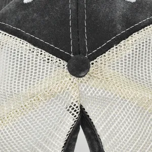 Close-up of black washed canvas baseball cap with beige mesh and white decorative stitching