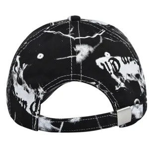 Detail of the back of a black tie-dye baseball cap with white graffiti and metal buckle
