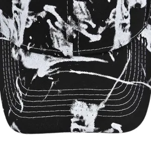 Detail of tie-dye baseball cap brim showing black marble pattern and neat stitching